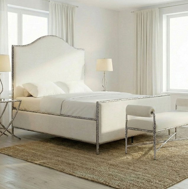 Vilber Gunmetal Silver Fully Upholstered Bed Neatly made bed in a bedroom with a bench and lamps.