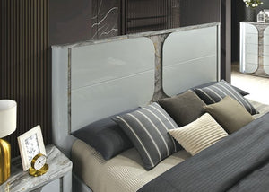 Vincenzo Modern High Gloss Finish LED Bed Modern bedroom with a bed featuring gray and beige pillows, a marble nightstand, and decorative elements.