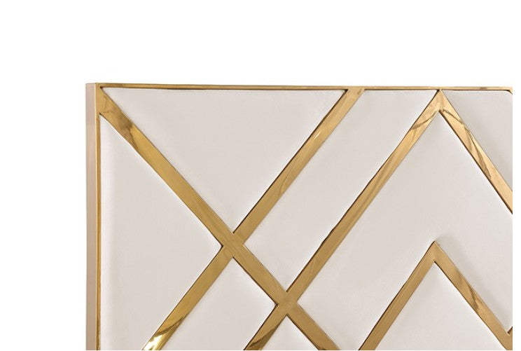 Violla Gold White Glam Upholstered Bed A modern white upholstered bed with a geometric gold headboard and gold base trim, styled in a bright, contemporary bedroom with matching white nightstands and gold accents.