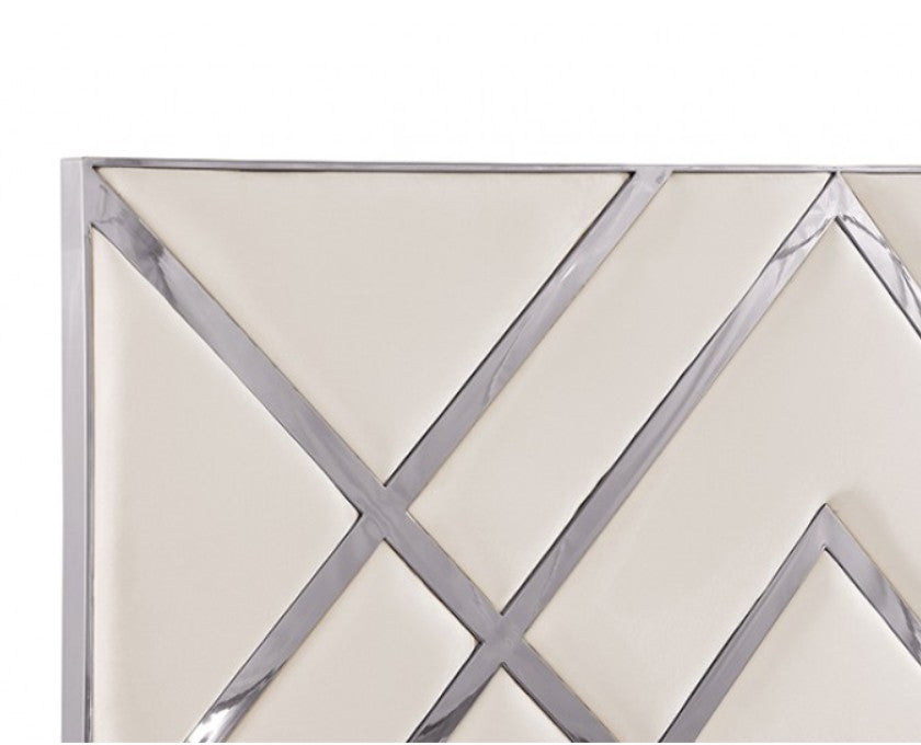 Violla Silver White Glam Upholstered Bed A modern white bed frame with a geometric diamond-patterned headboard, styled in a contemporary bedroom with white nightstands, lit table lamps, and a large arched window showing a city skyline.