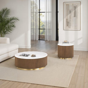 Modern living room with round coffee table and side table, featuring a couch and decorative elements.