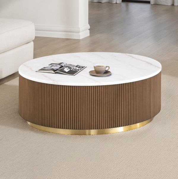 Round coffee table with a white top and brown ribbed base in a living room setting.