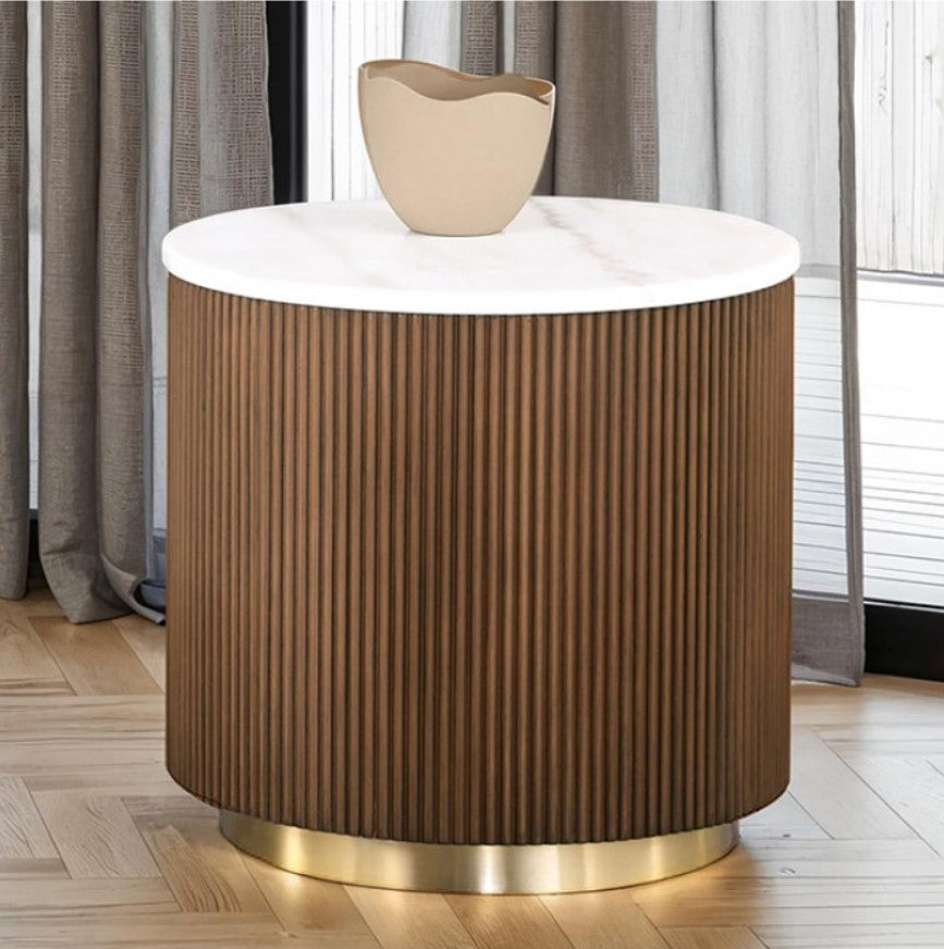 Round wooden side table with a white top and gold base in a room setting.