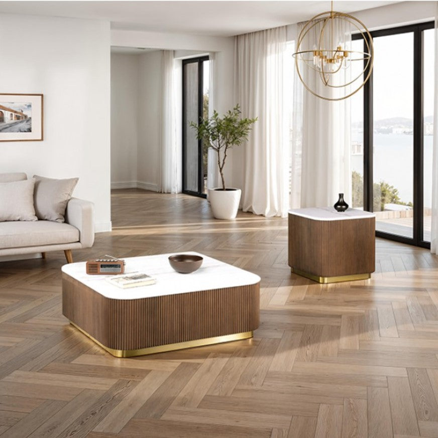 Modern coffee table with a white top and wooden base in a living room setting.