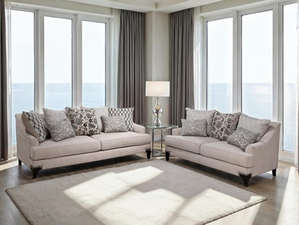 Living room with beige sofa set and large windows overlooking a scenic view.